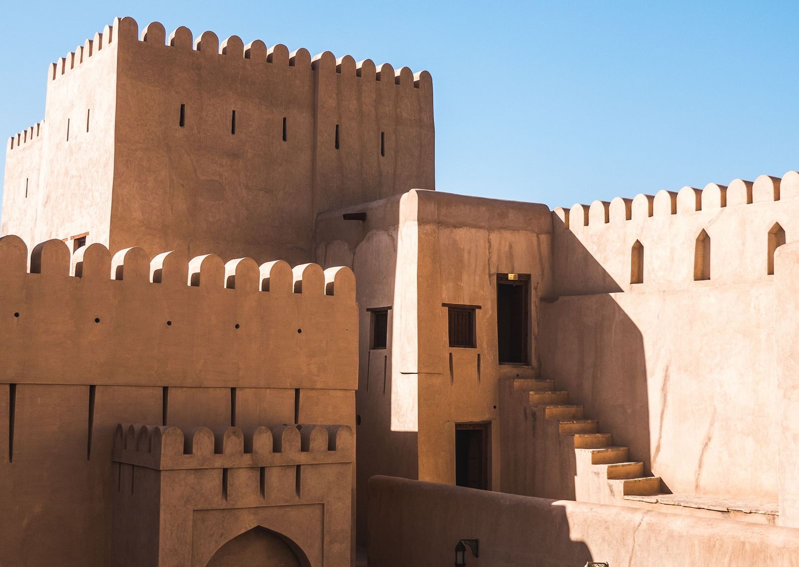 A fort with doors and steps leading to different rooms inside and the blue sky in the background